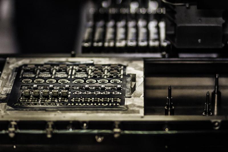 A completed panel of circuits exits the assembly machine. The machine completes in a few minutes what once took Ken Burns hours to build by hand.
