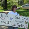 A woman holds up two anti-fracking signs at the rally near downtown Ravenna.