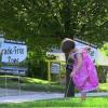 A small girl stakes an anti-fracking yard sign into the ground near the First Congregational Church near downtown Ravenna.