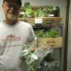 Dave Benchoff shows the scapes he brought to market from his organic farm in Ashland, Banzaf Garten. Benchoff is on the board of the Wooster Local Roots Cooperative and on the steering committee for Local Roots Ashland.