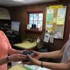 Volunteer Cindy Ducharme sells a box of first-of-the-season fresh-picked blueberries to shopper Louise Fleming Dufala.  