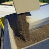 gathered sediment being ejected from the interceptor onto a conveyor belt